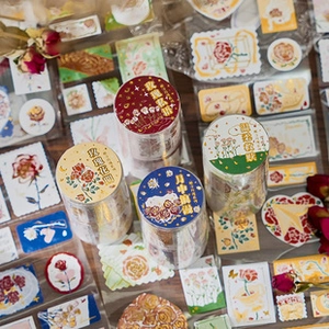 Macro view of vintage floral scrapbooking paper and rose washi tape set on wood