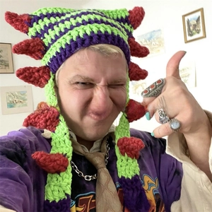 Detail of handmade striped crochet cat ear beanie with green purple stripes and red spikes