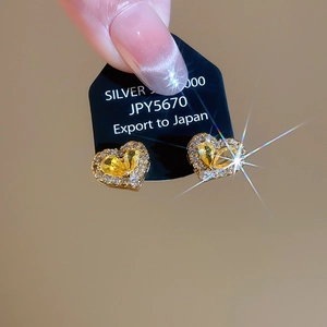Detail of 925 silver heart stud earrings with yellow gemstone and white zircons