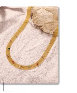 Detailed flat mesh necklace with colorful mixed-cut gemstones on white beach sand background