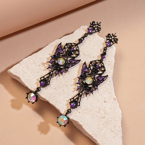 Detail of dark gothic butterfly earrings with purple enamel and iridescent crystals on stone
