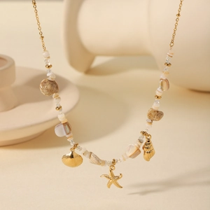 Detail of gold seashell and starfish charms on a beaded ocean-themed necklace