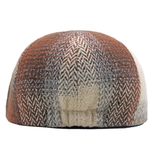 Detail shot of the colorful herringbone newsboy cap with warm orange and gray wool blend