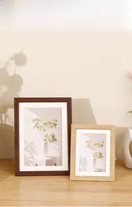 Close-up of walnut and natural wood photo frames with matting in a modern home setting