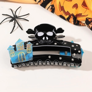 Detail of Halloween hair claw clip with skull crossbones and haunted house marble accent