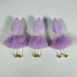 Detailed view of three purple fairy ornaments with sequin skirts and golden bell accents