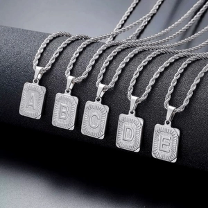 Detailed macro view of square silver pendants with letters A to E on steel rope chains