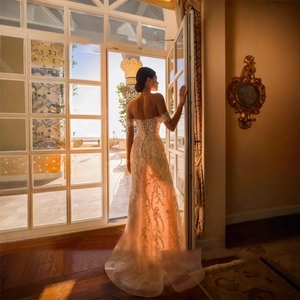 Elegant off-shoulder mermaid lace wedding gown with sweeping train in a scenic view