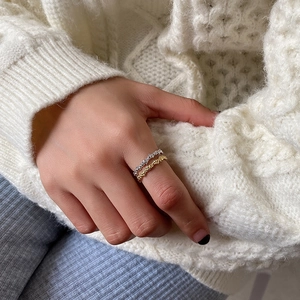Detailed shot of gold and silver S925 rings with woven texture on model's hand