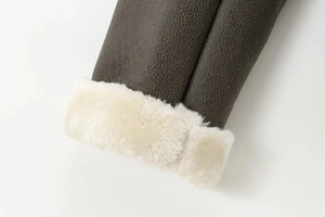 Detailed close-up of dark brown leather jacket cuff with white shearling lining trim