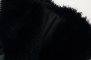 Gros plan du col en fourrure noire et de la doublure en satin de la veste en cuir