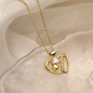 Detailed view of gold heart necklace with zircon stones on soft silk with ice accents