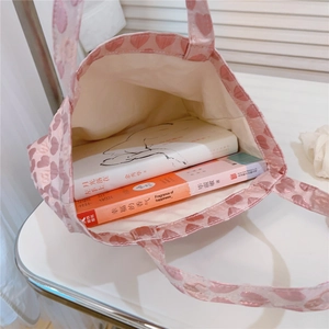 Macro view of pink heart pattern tote bag interior showing capacity and cream lining