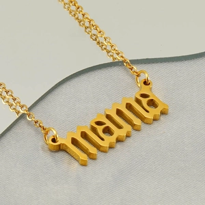 Macro shot of gold stainless steel mama pendant necklace in gothic font detail