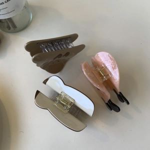 Tre mollette per capelli in acetato marrone, rosa marmorizzato e bicolore su bianco