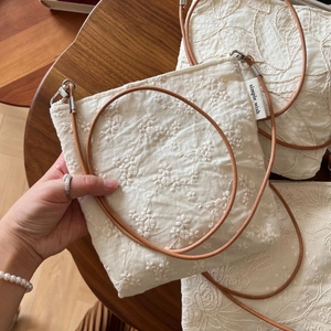 Embroidered beige cotton linen crossbody phone bag with floral patterns and leather strap