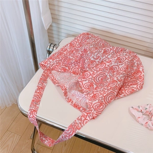 Detail view of red paisley canvas tote bag with matching floral scrunchie accessory