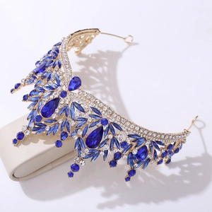 Detailed close-up of golden bridal crown with sparkling blue crystals and rhinestones