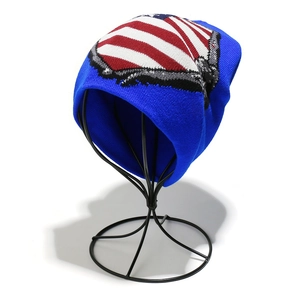 Detail of blue knit beanie featuring an American flag pattern on a hat stand