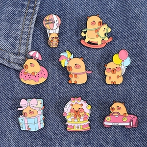 Detailed macro view of 8 colorful capybara enamel pins on a blue denim background