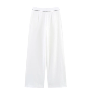 Détail du pantalon large blanc au design minimaliste à la taille et texture en lin