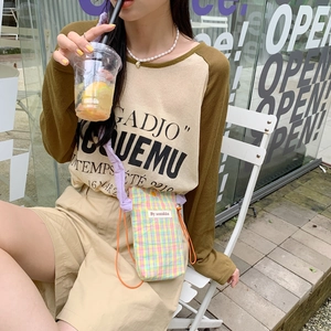Casual lifestyle view of a Korean style plaid mini crossbody phone bag on a model