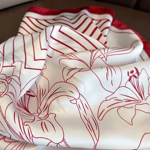 Close-up of red and white striped silk scarf featuring elegant lily floral patterns