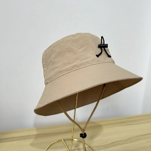 Khaki bucket hat detail with black adjustment buckle and adjustable chin strap