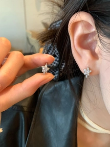Vue détaillée d'une boucle d'oreille étoile en argent avec zircons blancs portée