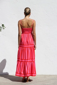 Back view of a striped backless maxi dress with pockets and elegant pleated details