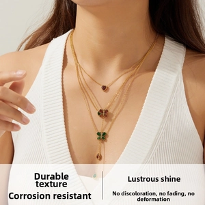Detail of layered gold butterfly and heart pendants with colorful gems and tassels
