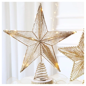 Close-up of champagne gold wire Christmas tree star topper with warm LED lights