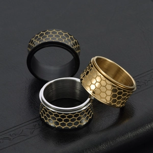 Luminous honeycomb spinner rings in gold, black and silver finishes on leather background