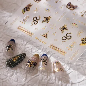 Macro detail of Egyptian nail stickers with gold Horus Eye and Anubis embossed patterns