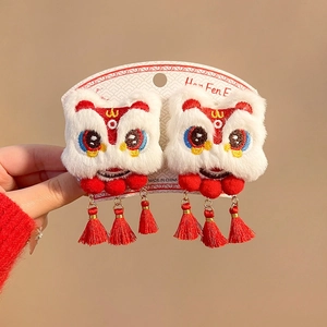 Detail view of New Year lion dance hair clips with plush pompoms and traditional red tassels
