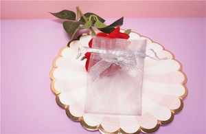 Macro detail of light purple organza gift bag with silver glitter bow and drawstring
