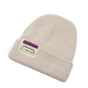 Detail of knitted beanie with creative boarding pass label showing stitching and texture