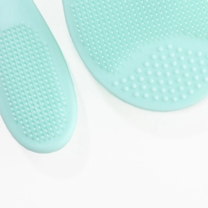 Macro detail of mint green silicone facial brush with soft cleaning bristles