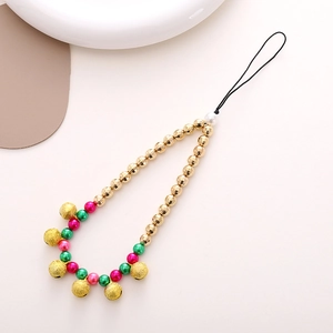 Christmas gold bead phone charm with red and green bells on a minimalist white surface