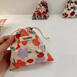 Close-up of floral cotton linen drawstring pouch with thick cord and brand label