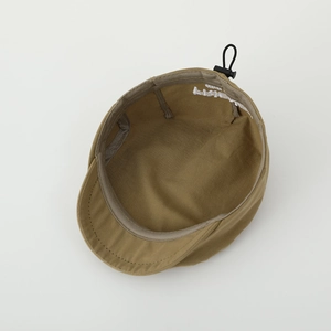 Detail view of khaki flat cap showing adjustable drawstring and internal fabric texture