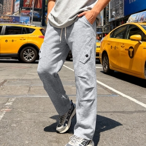 Dettaglio dei pantaloni cargo grigio chiaro con coulisse e ampie tasche laterali