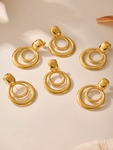 Detailed close-up of geometric multi-layered gold-plated stainless steel hoop earrings