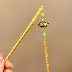Detailed shot of golden Chinese hair stick with fan pendant and blue silk tassels