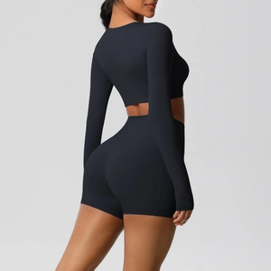 Detail van zwarte crop top met lange mouwen en yoga shorts op een model