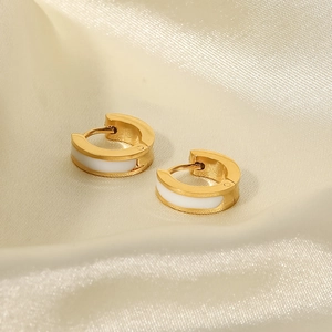 Macro shot of 18K gold plated hoop earrings with white enamel finish and secure hinge clasp