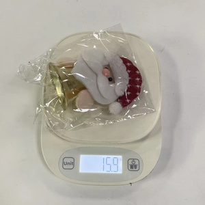 Detailed view of Santa Claus plush bell hanging ornament on weight scale 15.9 grams