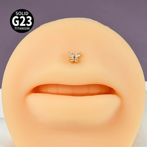 Macro shot of G23 titanium gold butterfly labret stud with zircon on a silicone model