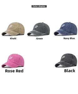 Detailed view of washed cotton baseball caps in five colors with heart embroidery