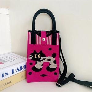 Detail of pink knitted bag featuring black cat pattern with adjustable shoulder strap